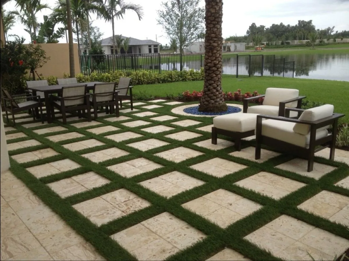 Artificial turf and travertine paver patio with lake view